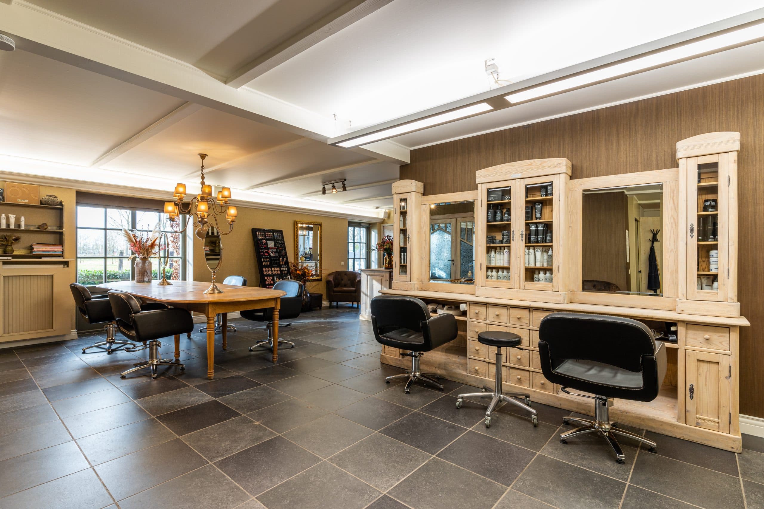 Het lichte kapsalon met kappersstoelen en spiegels