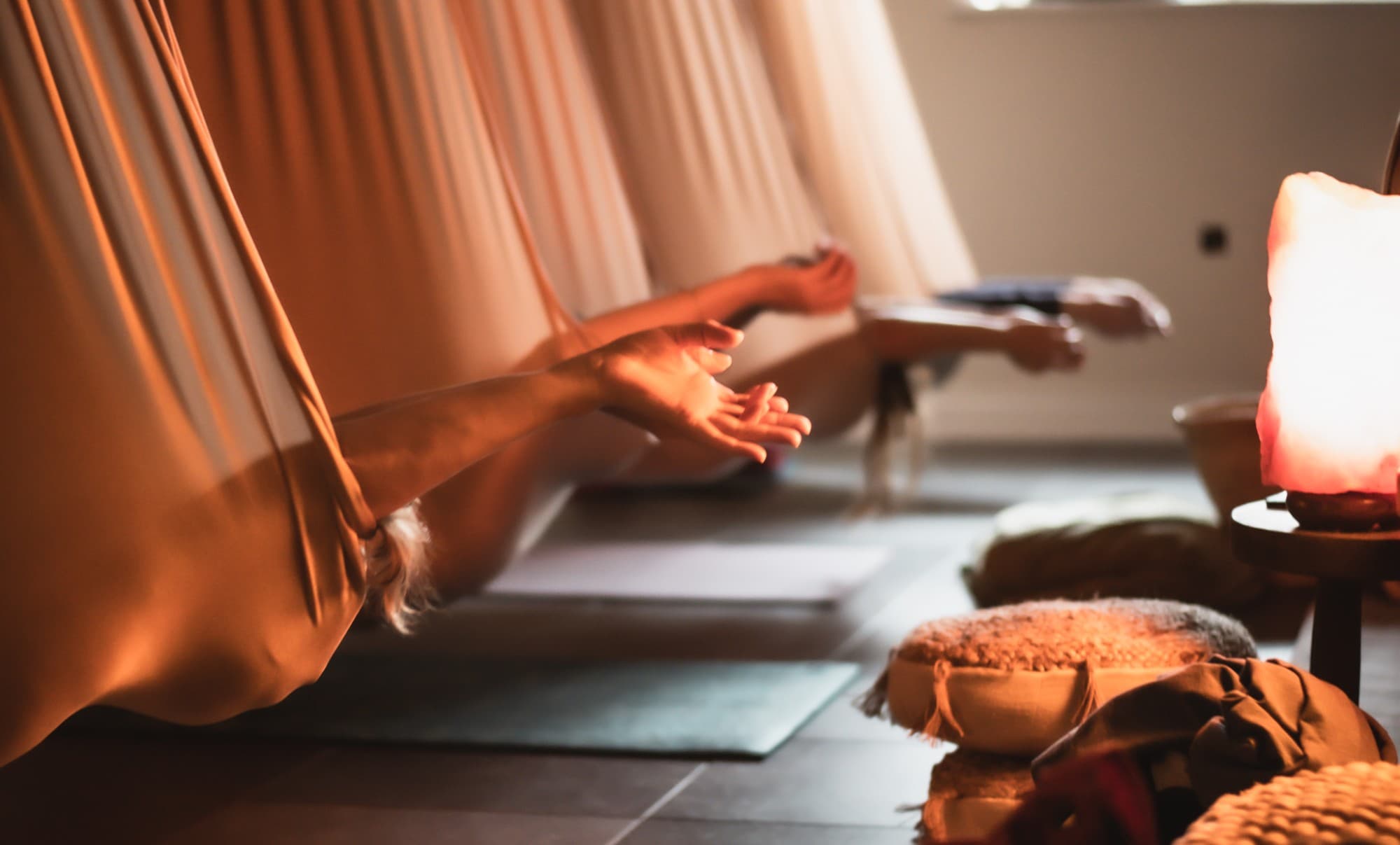 Aerial yoga in hangmatten bij zacht licht
